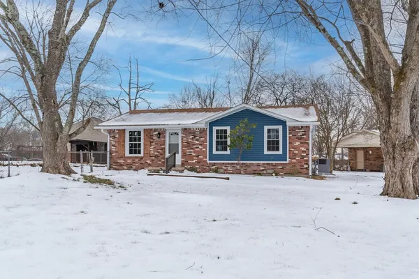 a front view of a house with a yard covered in snow