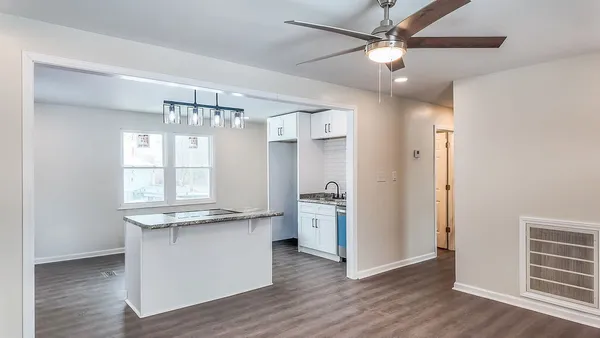 a view of a kitchen with wooden floor and a ceiling fan