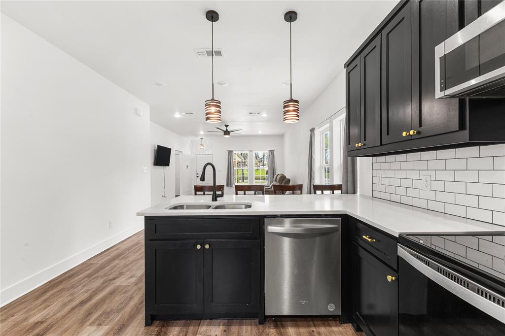 101 Ross Street Sulphur Springs, TX 75482 - Photo 9 of 29 a kitchen with stainless steel appliances granite countertop a sink a stove and a wooden floors