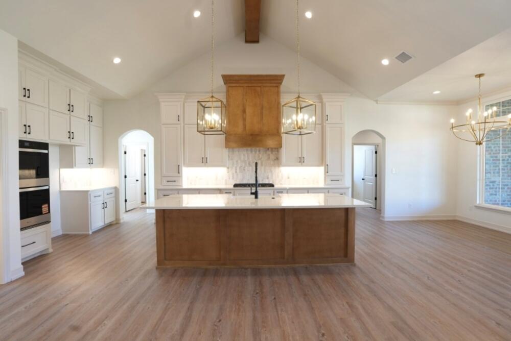 4620 143rd Street Lubbock, TX 79424 - Photo 3 of 25 a large kitchen with stainless steel appliances a large counter top a stove and a wooden floors