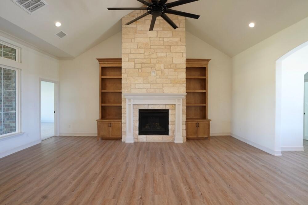4620 143rd Street Lubbock, TX 79424 - Photo 4 of 25 an empty room with wooden floor a chandelier fan and windows