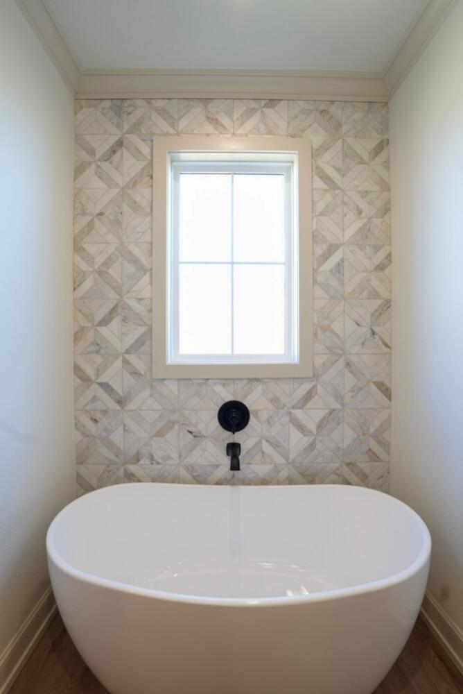 4620 143rd Street Lubbock, TX 79424 - Photo 9 of 25 a white bath tub sitting in a bathroom next to a window
