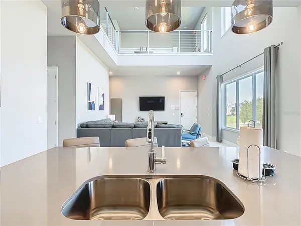 a kitchen with a stove a sink a microwave oven a dining table and chairs with wooden floor