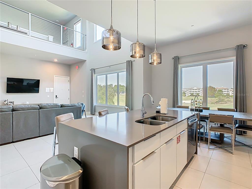 7740 Sandy Ridge Drive, Unit 245 Reunion, FL 34747 - Photo 15 of 57 a kitchen with a stove a sink a microwave oven a dining table and chairs with wooden floor