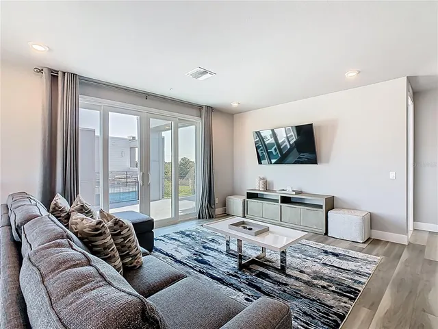 a living room with furniture a table and wooden floor