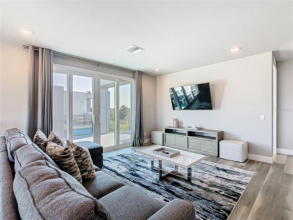7740 Sandy Ridge Drive, Unit 245 Reunion, FL 34747 - Photo 21 of 57 a living room with furniture and a flat screen tv