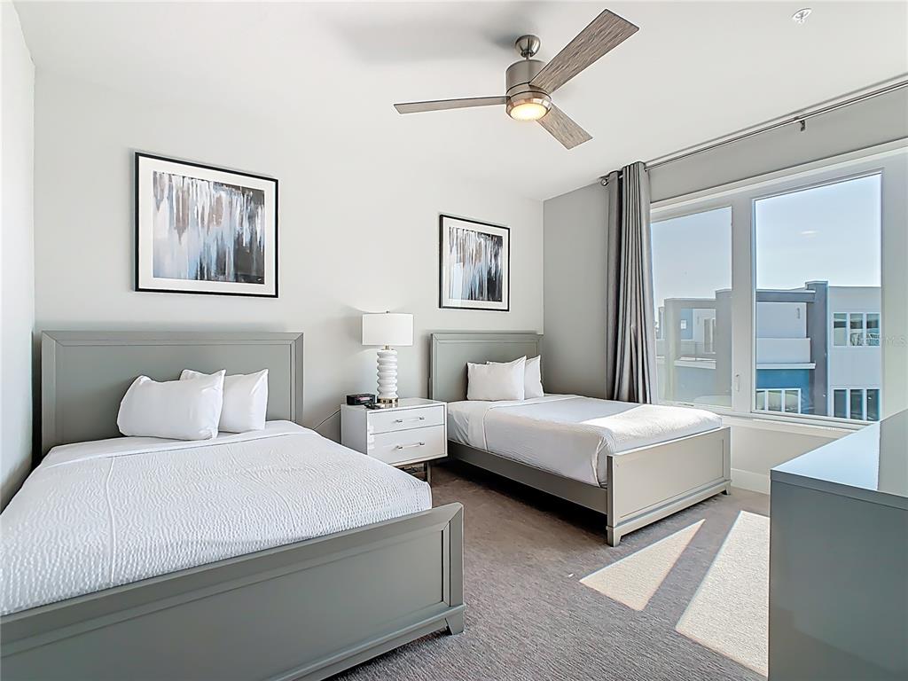 7740 Sandy Ridge Drive, Unit 245 Reunion, FL 34747 - Photo 26 of 57 a bedroom with two beds and a large window
