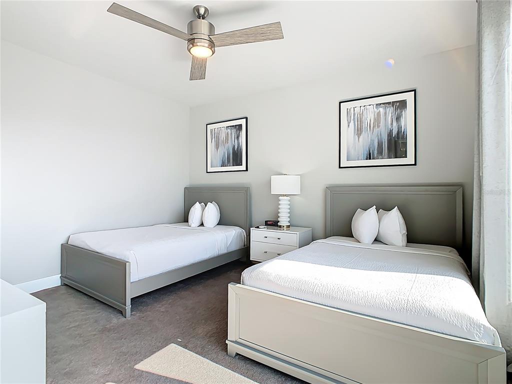 7740 Sandy Ridge Drive, Unit 245 Reunion, FL 34747 - Photo 27 of 57 a bedroom with two beds and painting on the wall