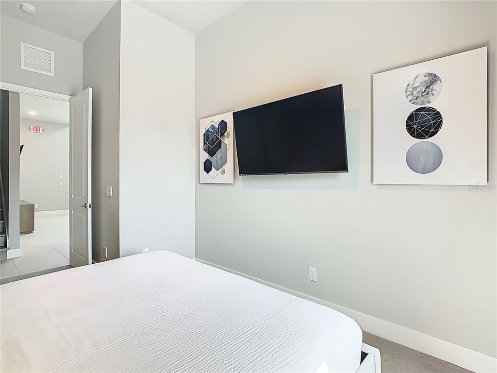 7740 Sandy Ridge Drive, Unit 245 Reunion, FL 34747 - Photo 34 of 57 a bedroom with a bed and a television
