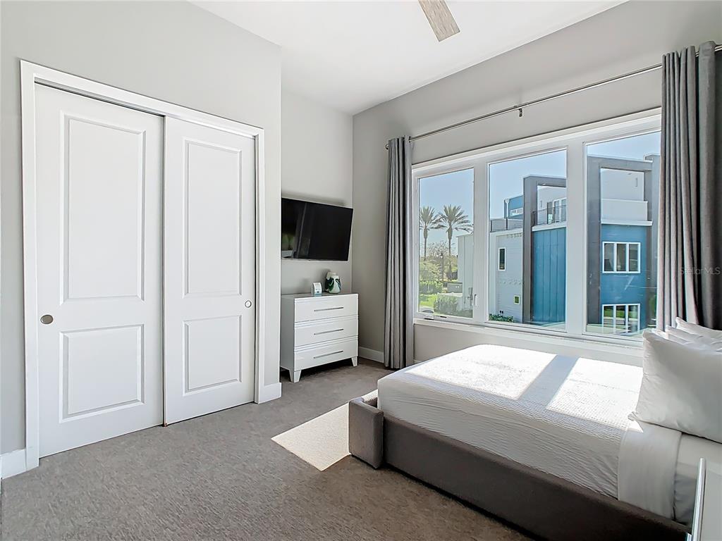 7740 Sandy Ridge Drive, Unit 245 Reunion, FL 34747 - Photo 41 of 57 a bedroom with a bed and a flat tv screen