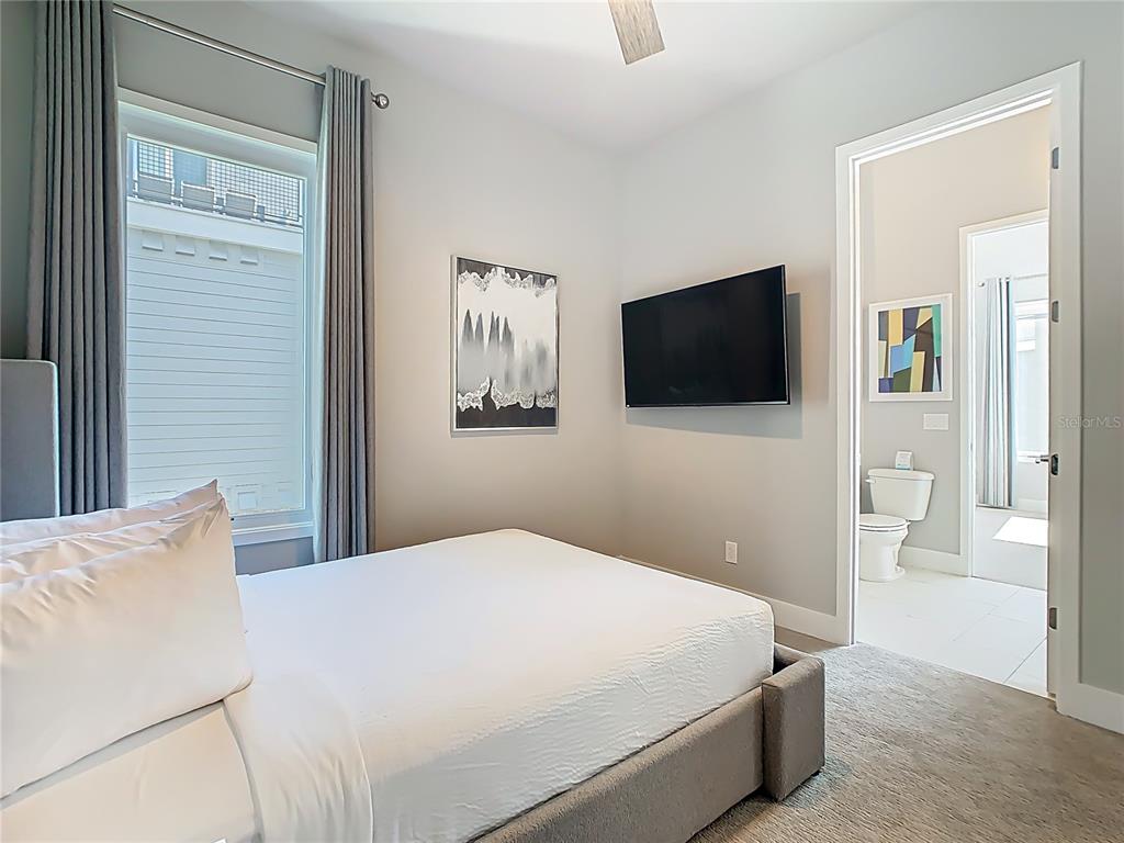 7740 Sandy Ridge Drive, Unit 245 Reunion, FL 34747 - Photo 48 of 57 a bedroom with a bed and a flat screen tv