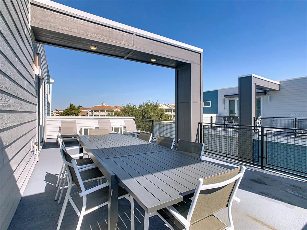 7740 Sandy Ridge Drive, Unit 245 Reunion, FL 34747 - Photo 51 of 57 a view of a roof deck with table and chairs with wooden floor and fence