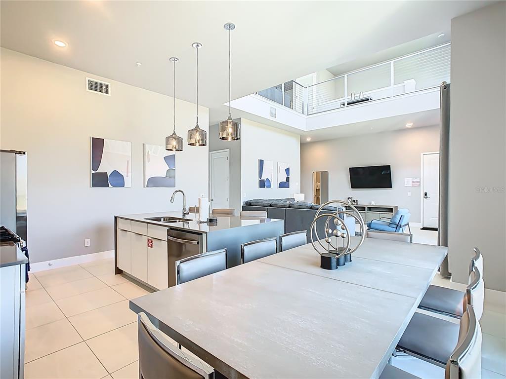 7740 Sandy Ridge Drive, Unit 245 Reunion, FL 34747 - Photo 10 of 57 a kitchen with stainless steel appliances kitchen island granite countertop a stove a sink and a refrigerator