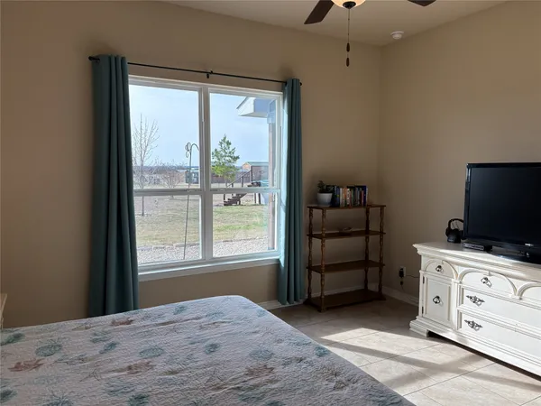 a bedroom with a bed and a flat tv screen on the dresser