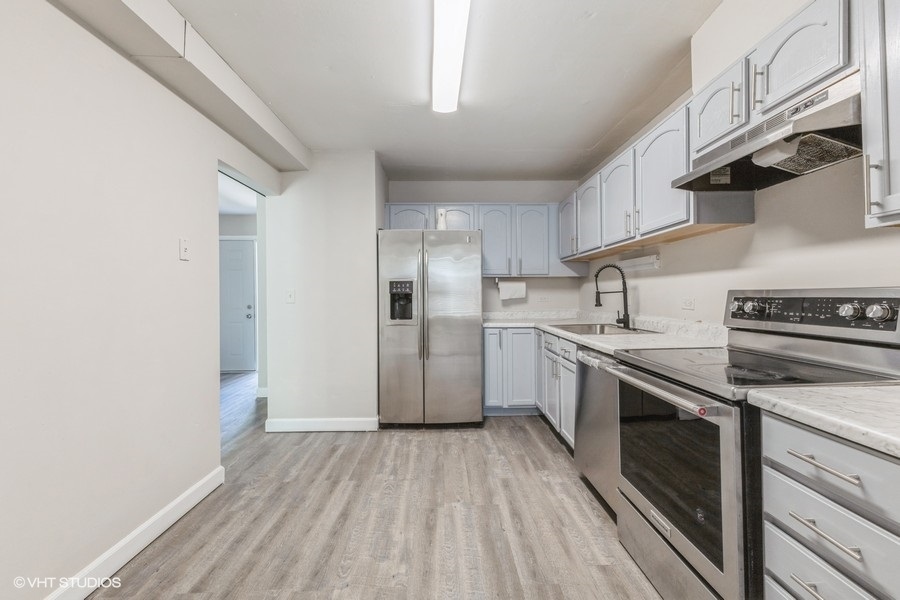 207 Walker Drive Bolingbrook, IL 60440 - Photo 3 of 18 a kitchen with stainless steel appliances granite countertop a sink a stove a refrigerator and cabinets