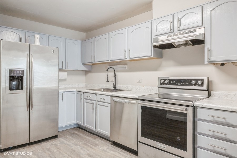 207 Walker Drive Bolingbrook, IL 60440 - Photo 4 of 18 a kitchen with cabinets stainless steel appliances and sink