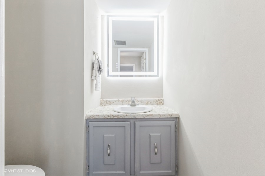 207 Walker Drive Bolingbrook, IL 60440 - Photo 9 of 18 a bathroom with a granite countertop sink and a mirror