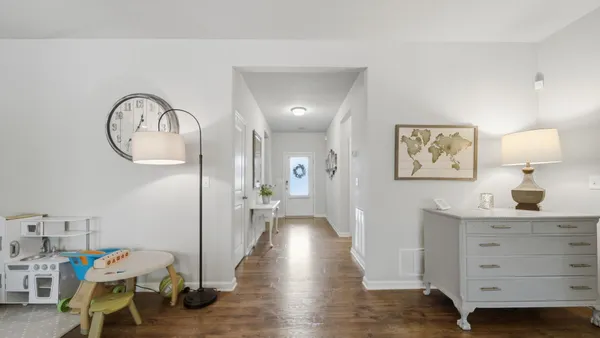 a view of a hallway to a livingroom with furniture and wooden floor