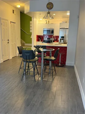 a room with stainless steel appliances kitchen island granite countertop furniture and a wooden floor