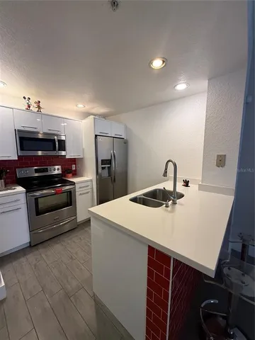 a kitchen with a sink and stainless steel appliances