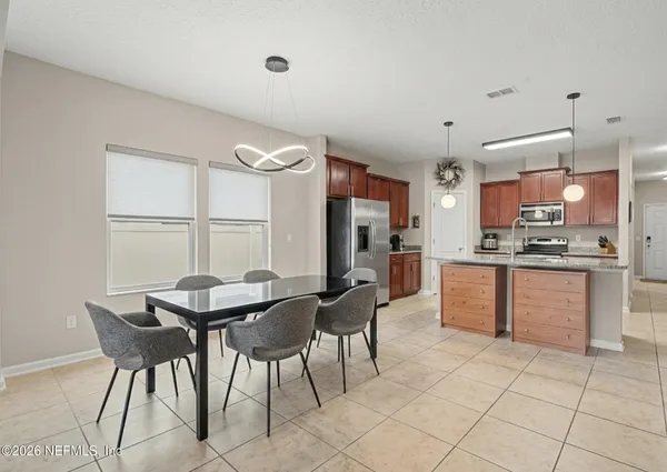 a kitchen with stainless steel appliances granite countertop a stove a refrigerator a kitchen island with chairs and cabinets