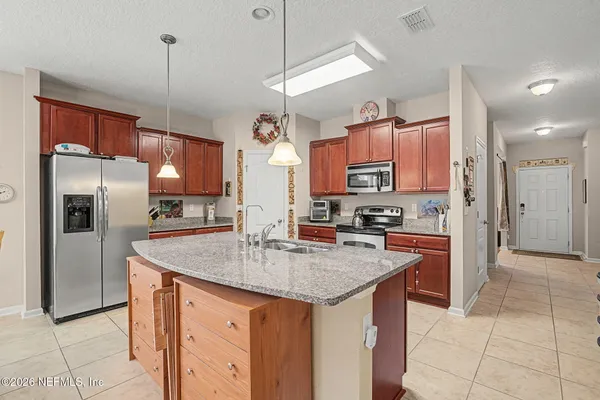 a kitchen with granite countertop a sink and a refrigerator