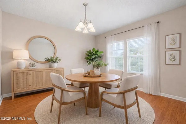 a dining room with furniture a potted plant and a chandelier