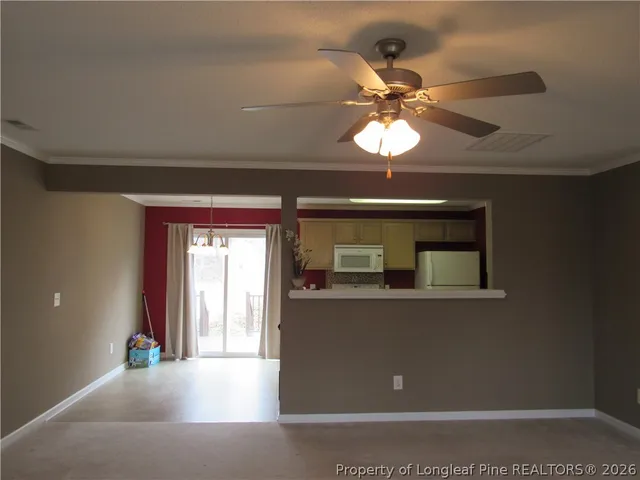 a view of a livingroom with a chandelier fan and a window