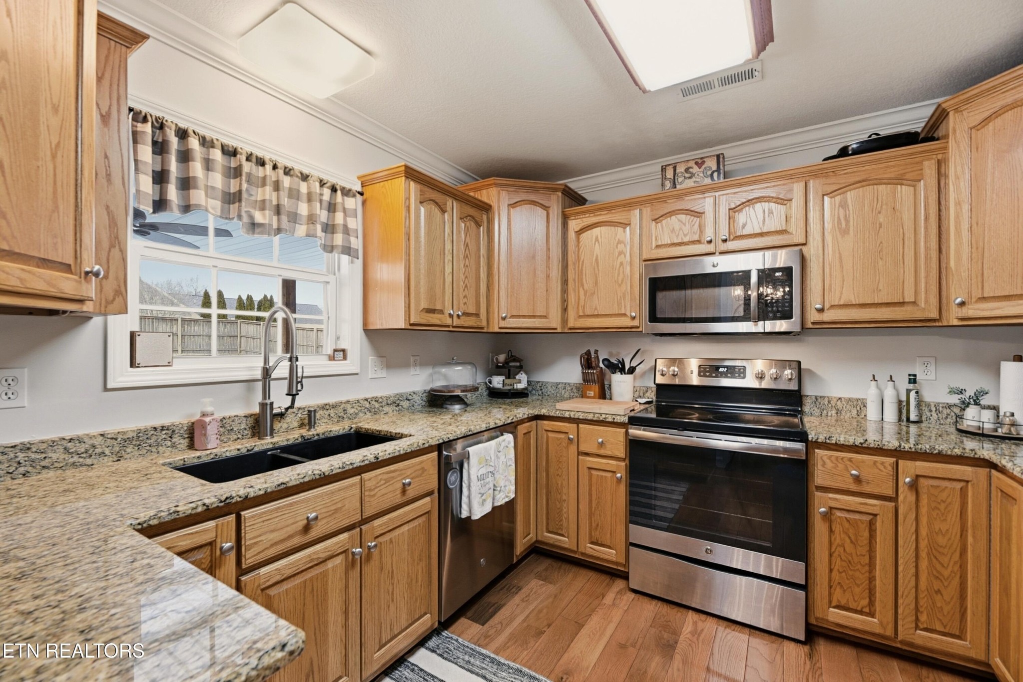 117 Elizabethton Way Clinton, TN 37716 - Photo 12 of 41 a kitchen with stainless steel appliances granite countertop white cabinets granite counter tops and a hard wood floors