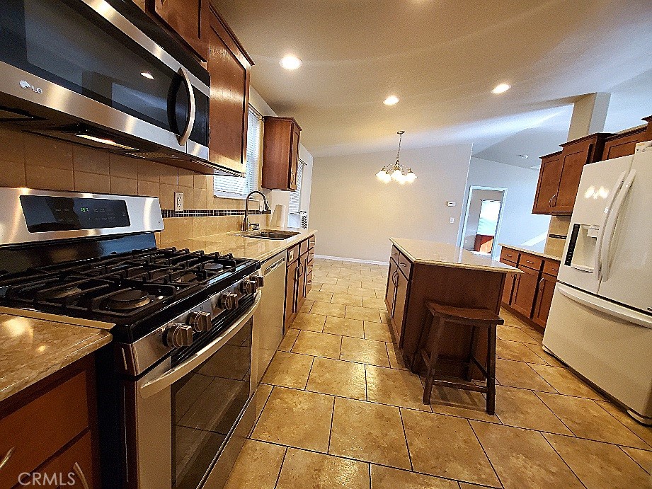 21621 Sandia Road, Unit 127 Apple Valley, CA 92308 - Photo 13 of 43 a kitchen with stainless steel appliances granite countertop a stove a sink and a microwave