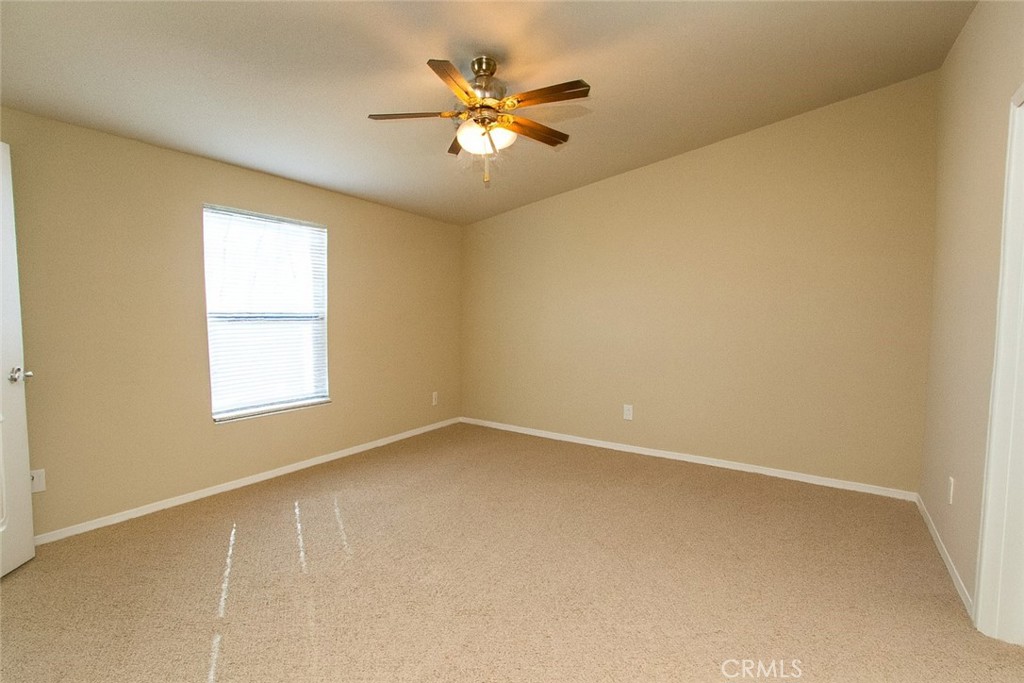 21621 Sandia Road, Unit 127 Apple Valley, CA 92308 - Photo 16 of 43 an empty room with a window and a ceiling fan
