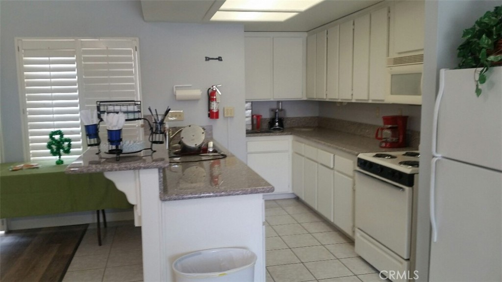 21621 Sandia Road, Unit 127 Apple Valley, CA 92308 - Photo 41 of 43 a kitchen with a sink cabinets and window