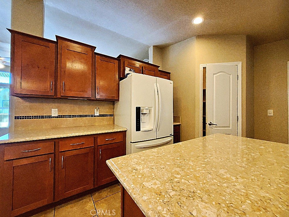 21621 Sandia Road, Unit 127 Apple Valley, CA 92308 - Photo 10 of 43 a kitchen with stainless steel appliances granite countertop a refrigerator a sink and wooden cabinets