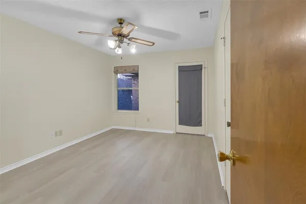 an empty room with closet and windows