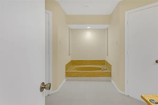 a bathroom with a tub sink and mirror