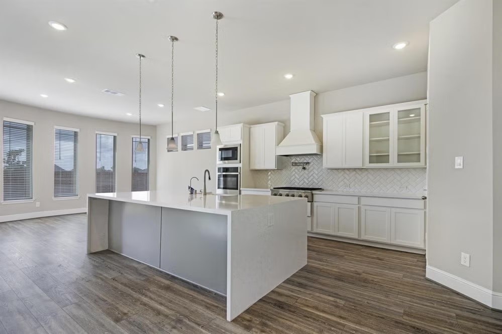 6418 Seville Street Manvel, TX 77578 - Photo 4 of 7 a large kitchen with cabinets wooden floor and stainless steel appliances