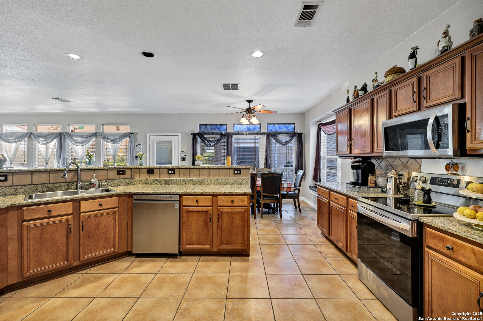 1611 Springhouse Street San Antonio, TX 78251 - Photo 10 of 30 a kitchen with stainless steel appliances granite countertop a sink counter space cabinets and a large window