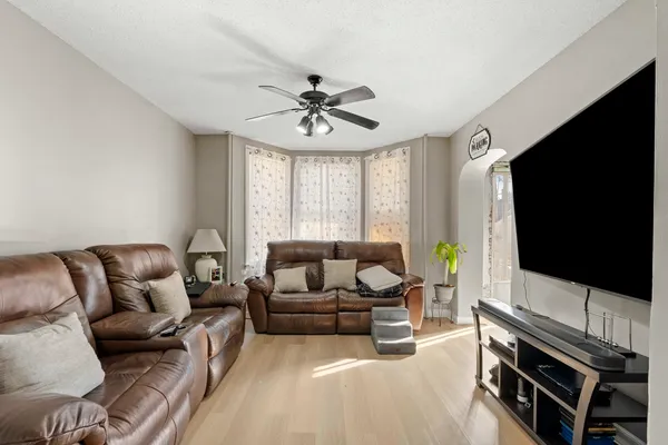 a living room with furniture a flat screen tv and a window