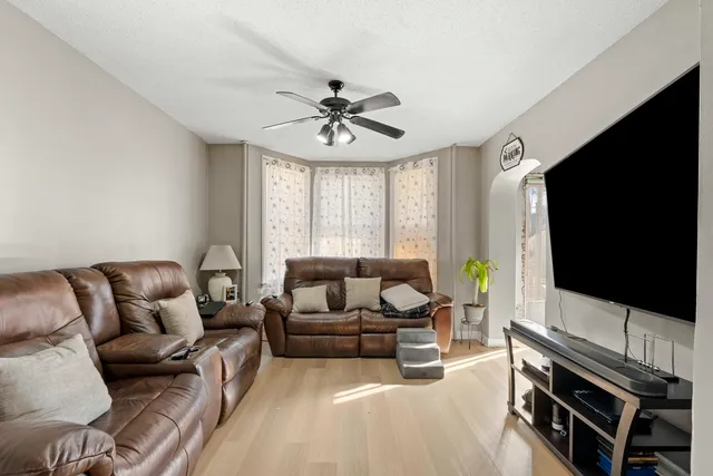 a living room with furniture a flat screen tv and a window