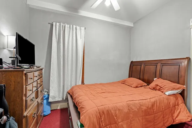 a bedroom with a bed flat screen tv and a window