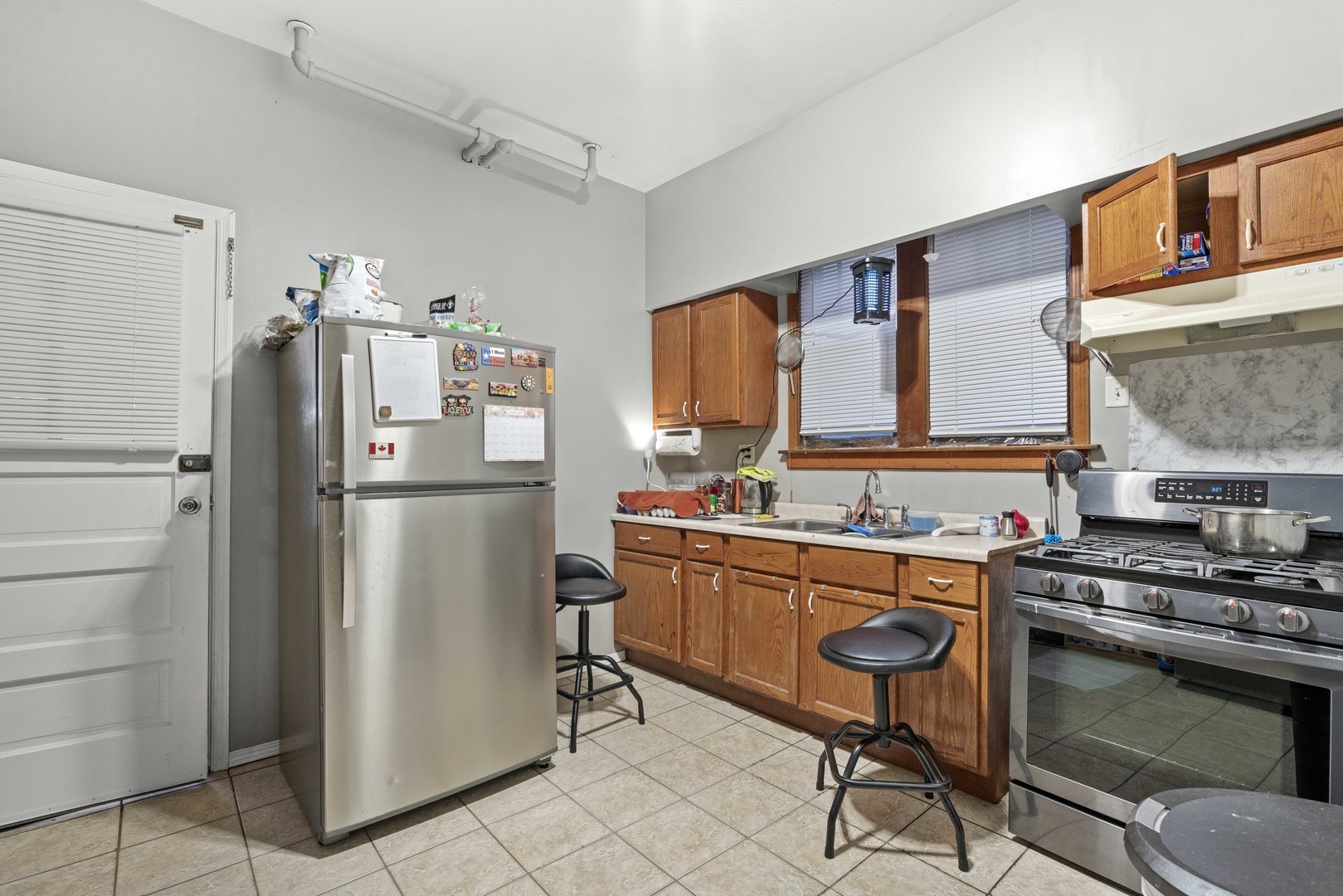 2922 East 97th Street Chicago, IL 60617 - Photo 17 of 20 a kitchen with stainless steel appliances a refrigerator stove and sink