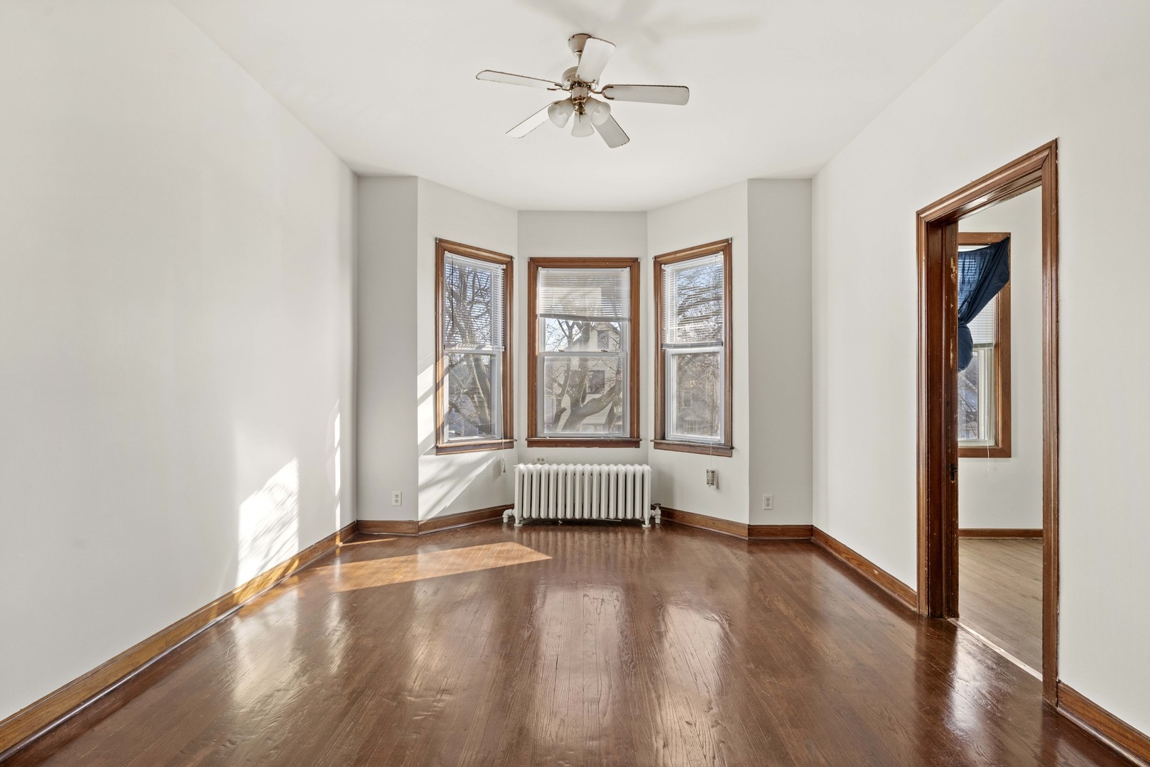 2922 East 97th Street Chicago, IL 60617 - Photo 3 of 20 an empty room with wooden floor and windows