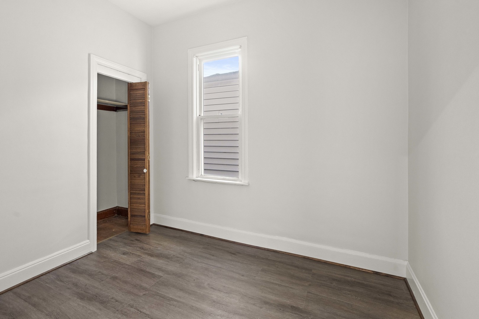 2922 East 97th Street Chicago, IL 60617 - Photo 9 of 20 a view of an empty room with wooden floor and a window