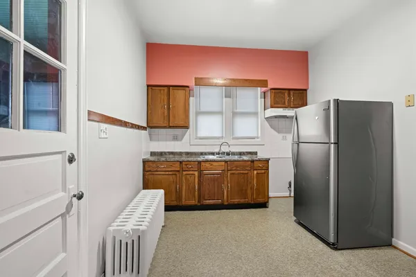 a kitchen with stainless steel appliances granite countertop a refrigerator a stove and a sink