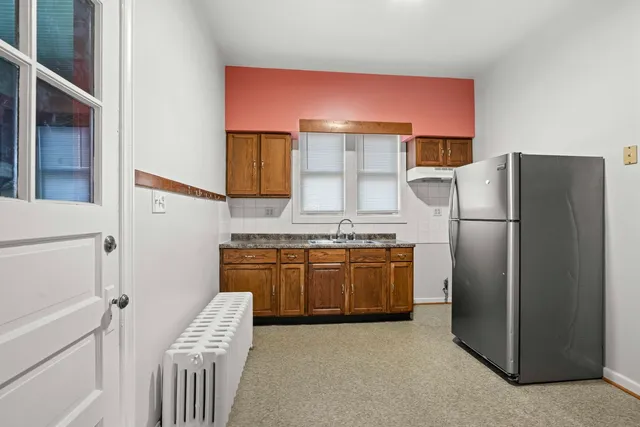 a kitchen with stainless steel appliances granite countertop a refrigerator a stove and a sink
