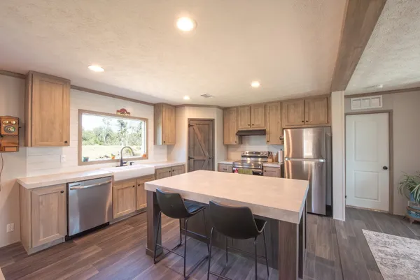 a kitchen with a table chairs refrigerator and cabinets