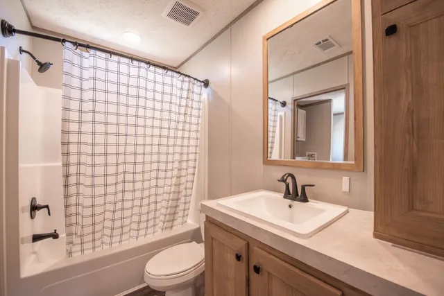a bathroom with a sink a toilet and shower curtain