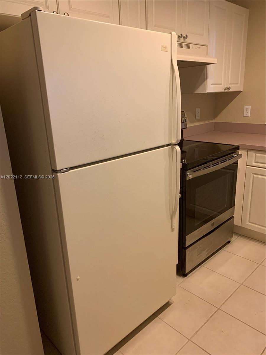 6572 West Sample Road, Unit 6572 Coral Springs, FL 33067 - Photo 3 of 17 a white refrigerator freezer and a stove sitting inside of a kitchen