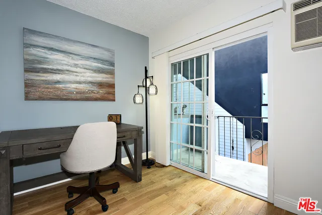 a view of a workspace with furniture and a window