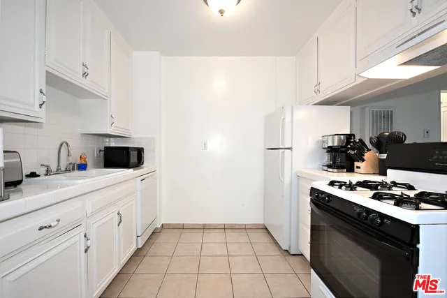 a kitchen with appliances a sink and cabinets